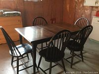 Photo showing solid black maple rectangular dining table and five matching spindle back chairs arranged around it.