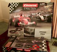 Full view of Carrera Evolution Grand Prix slot car race set box showing two race cars on track and extra track pieces in packaging.