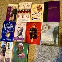 Photo showing 11 books related to the British royal family laid out on carpet.