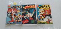 Front covers of three Dell Nukla comic books, issues #1, #2, and #4, placed side by side on a white surface, each in protective plastic sleeve.