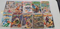 10 vintage DC comic books displayed front side including Showcase #51, Super Friends, Teen Titans with visible wear.
