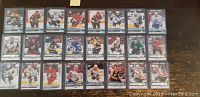 24 Young Gun rookie hockey cards arranged in 4 rows of 6 on a flat surface, cards sleeved and featuring various NHL players in action.