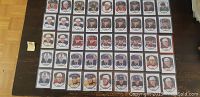 Photo of 45 Upper Deck Rookie Portraits hockey cards from the 2015/16 set, arranged in rows in protective plastic sleeves on a wooden floor. Includes duplicates.