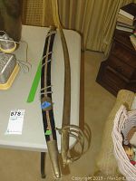 Full view of the sword with curved blade, scabbard, and black velvet quiver with gold trim.