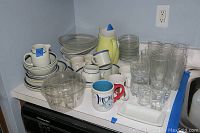 Full view of dinnerware and glassware set arranged on kitchen counter.