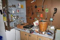 Garage workbench and pegboard with hand tools, hardware, and storage containers.