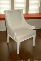 Front angled view of the upholstered white chair showing the seat, backrest, and painted white frame.