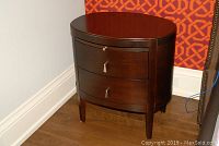Front view of oval night table showing two drawers and curved profile