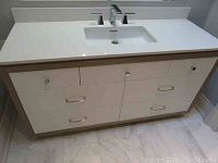 Front view of vanity showing quartz countertop, integrated sink, six drawers and chrome hardware