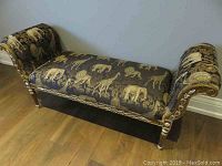 Front view of bench showing animal print upholstery and carved gilt frame