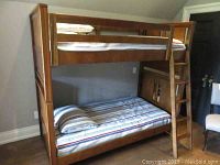 Front view of entire bunk bed assembly with two striped mattresses