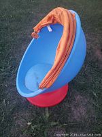 Blue egg-shaped infant mobile seat with red base, canopy folded