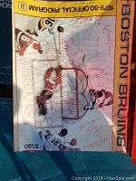 Front cover of the 1979-1980 Boston Bruins official program featuring ice hockey players in action and numerous signatures.