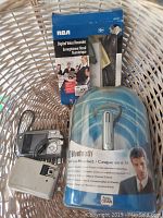 Basket holding the boxed RCA Digital Voice Recorder, the sealed Fone Gear Bluetooth Headset, and the Olympus Stylus Verve 120 camera