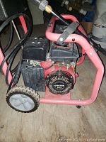 Front view of the pressure washer showing engine, wheels and frame