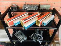 Full set on three-tier shelf: locomotive, tender, transformer, boxed cars and track