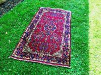 Full view of rug laid on grass, showing overall size and pattern symmetry.