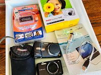 Top view of lot showing lumbar camera, Samsung camera, MagicJack device, boxed Kodak camera and USB pump