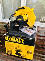 Chop saw mounted on original box with instruction manual on top