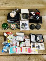 Overview of entire lot showing multiple reels, fly fishing tackle boxes, lures, fishing line, and bobbers.