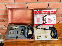 Both Badger Air Brush kits with original boxes and setup shown against brick wall.