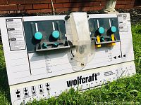 Front view of Wolfcraft router table top showing fences, knobs, printed scales