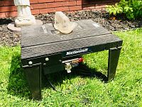 Front angle view of Mastercraft black plastic router table showing brand label and dust collection hood.