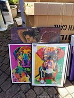 View of entire lot showing original nude painting behind two framed colorful dog prints.