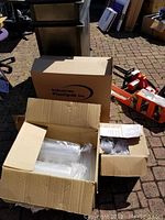 Cardboard boxes containing plastic serving containers and lids in original packaging set outdoors.