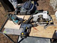 Photo showing the Black and Decker Quantum circular saw, Makita palm sander, and MasterCraft hammer drill on plywood.