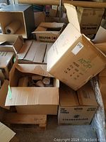 Boxes of various disposable cups and lids, some open showing contents, including branded boxes for StrongHolder and ATCP.