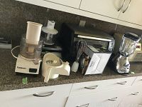 Countertop with Cuisinart Little Pro food processor, Black & Decker toaster oven, small kitchen appliances, and a blender.