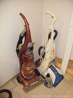 Photo showing both Bissell devices (vacuum and steamer) along with manuals and cleaning bottle arranged in corner