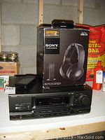 Technics SA-GX690 AV Control Stereo Receiver with Sony wireless headphones in box displayed on a table.