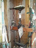 Minn Kota Endura electric trolling motor mounted in storage, visible red and black power cables, wooden mounting beam