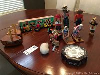 Overview photo showing the dolls, wooden boats, and the wooden train set on a table.
