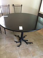 Overall view of round black granite tabletop and metal base with two chairs