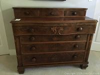 Front view showing the solid wood dresser with decorative inlay detail on top large drawer and three smaller removable top drawers.