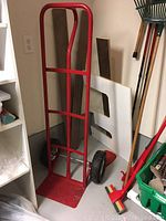 Full view of the red upright dolly showing frame and base plate.