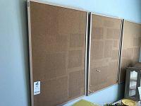 Three cork boards with wooden frames mounted on wall side by side, each measuring 24x40 inches, lightly used with pinholes visible.