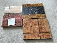 Three encaustic wax art blocks arranged on the floor showing their size and textured designs.