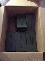 Cardboard box containing five metal ammo tins arranged in two rows, three on bottom and two on top.