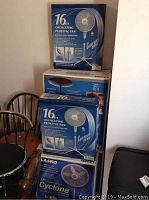 Seven fans in original boxes stacked, showing Comfort Zone and Lasko brands.