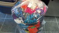 Photo of multiple new bathing suits and lingerie in a transparent plastic bag on tiled floor