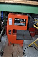 Front view of the Black & Decker orange drill powered band saw, showing the worktable and blade slot.