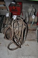 Photo showing three electric motors with cables and hoses, some mounted on metal and wooden bases, tagged with inventory numbers.