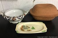 Photo showing all three items: a ceramic serving bowl, a small plate, and a clay covered baker.