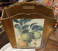 Front view of Italian wooden magazine holder with botanical illustration of fruits and cutout handle
