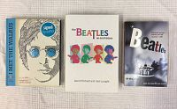 Photo of the three Beatles books in a single row shows covers: I Met The Walrus with signed by author sticker, The Beatles an Oral History with colorful illustrated band member art, and The Beatles softcover with black and white photo on cover