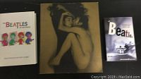 Photo of three books: two softcover and one hardcover, with Beatles and artistic photography covers